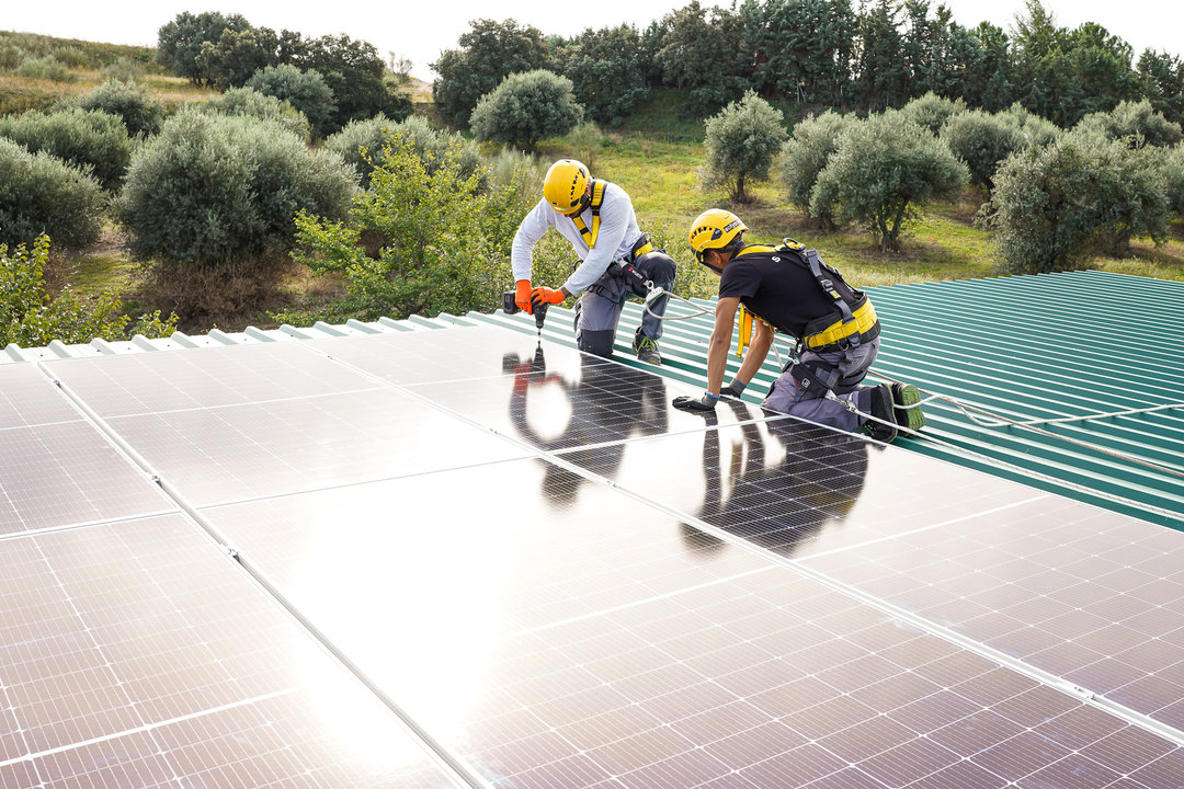 Dos trabajadores de SotySolar instalando paneles.